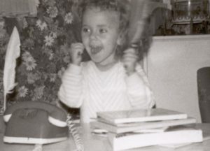 Sabrina Tomasi als Kind am Schreibtisch, jubelnd.